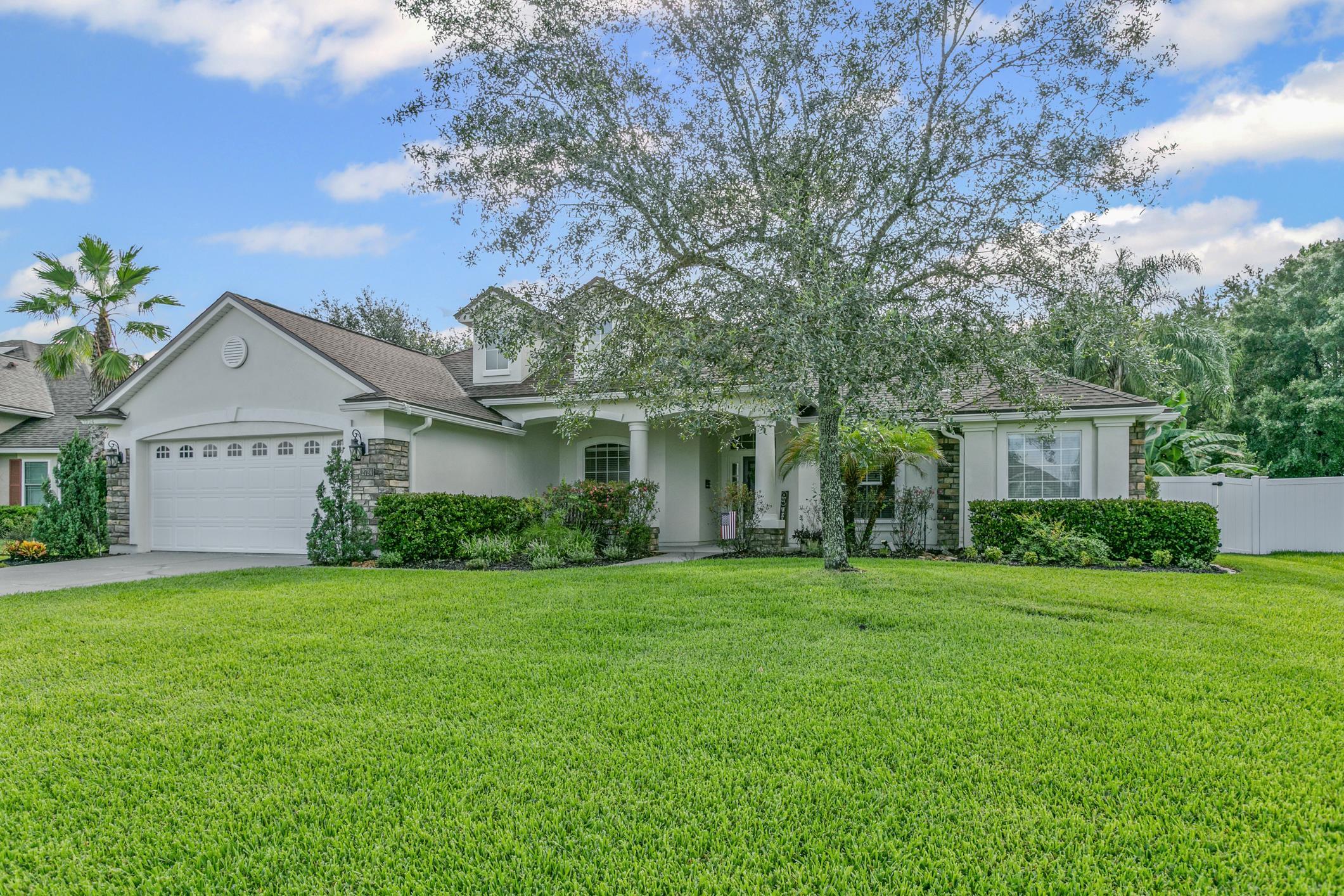 2724 North Portofino Road St. Augustine, FL 32092 - Photo 9 of 86 View of front of property featuring stone siding, stucco siding, a garage, concrete driveway, and a shingled roof