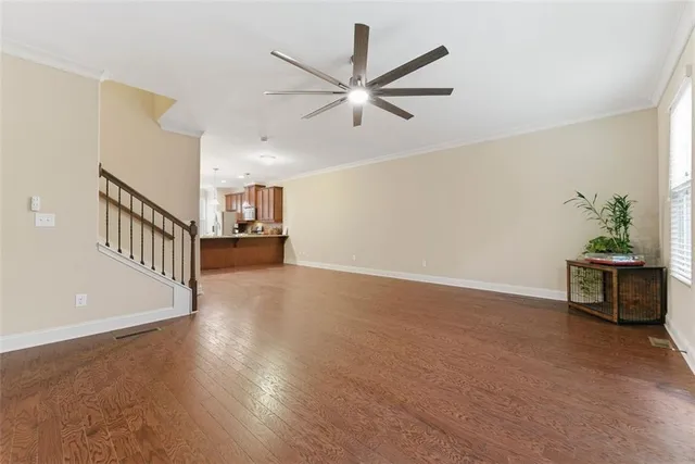 a view of an empty room with a window and wooden floor