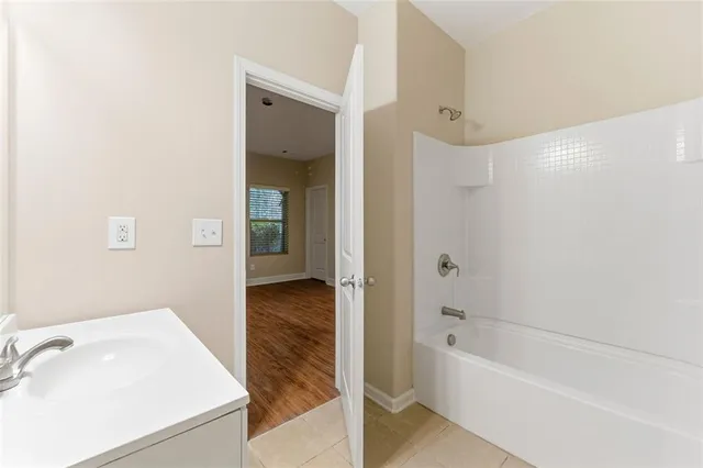 a bathroom with a tub a sink and a mirror