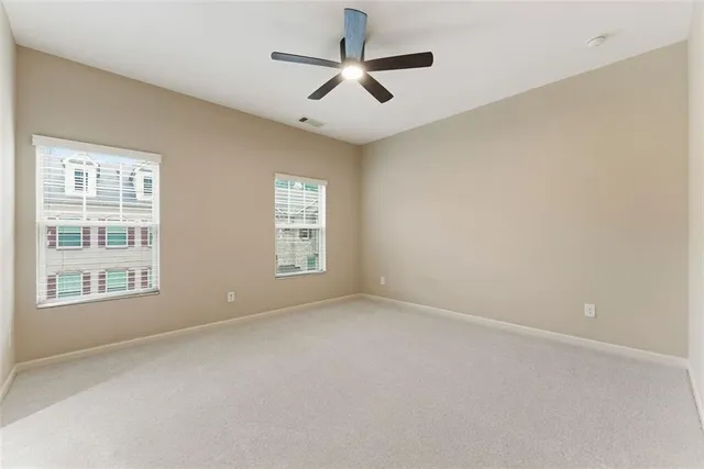 an empty room with closet and fan