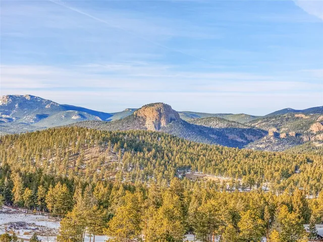 a view of a large mountain with a mountain in the background