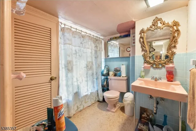 a bathroom with a sink a toilet and shower curtain