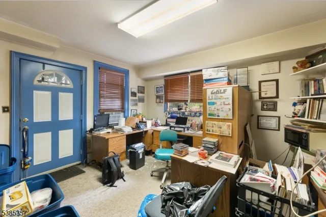 a living room with furniture a bookshelf and a window