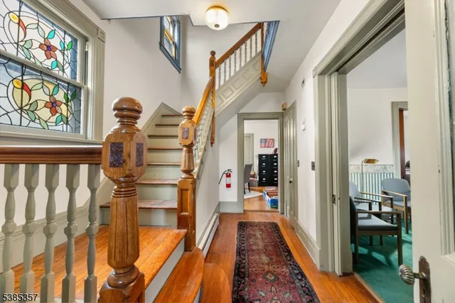 a view of hallway with wooden floor and stairs