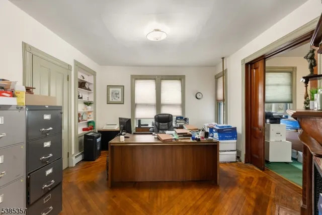 a room with kitchen island stainless steel appliances furniture a large window and a refrigerator