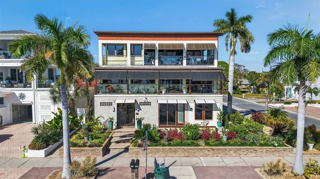 front view of a house with a yard and potted plants
