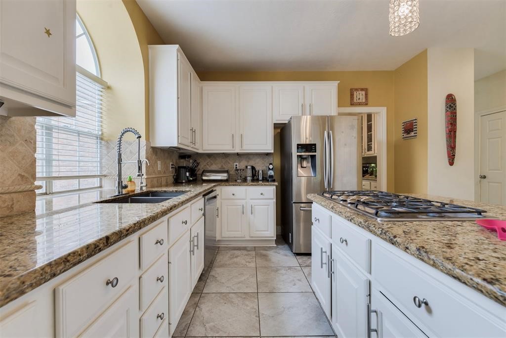 14103 Heatherhill Place Houston, TX 77077 - Photo 13 of 47 a kitchen with granite countertop a sink stove refrigerator and cabinets