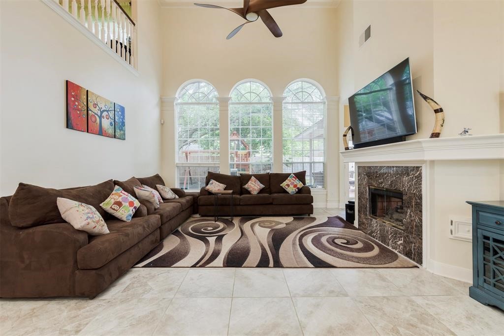 14103 Heatherhill Place Houston, TX 77077 - Photo 18 of 47 a living room with furniture a fireplace and a flat screen tv