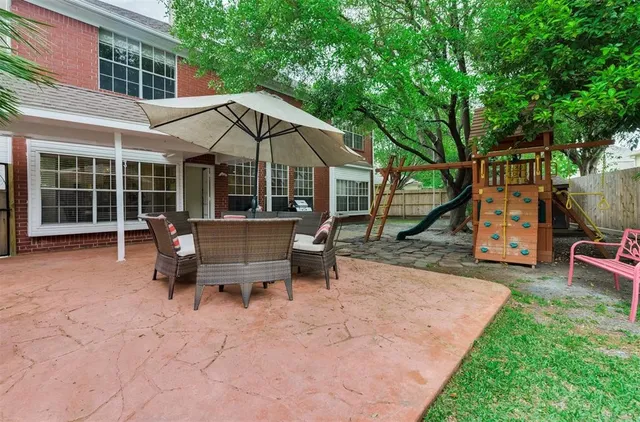 a view of a house with backyard and sitting area