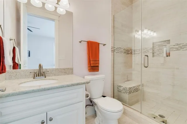 a bathroom with a sink toilet vanity and shower
