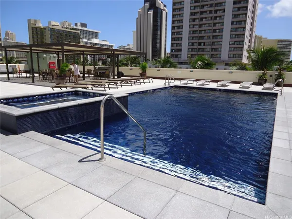 a swimming pool with outdoor seating and city view