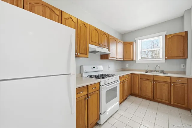 a kitchen with cabinets appliances a sink and a window