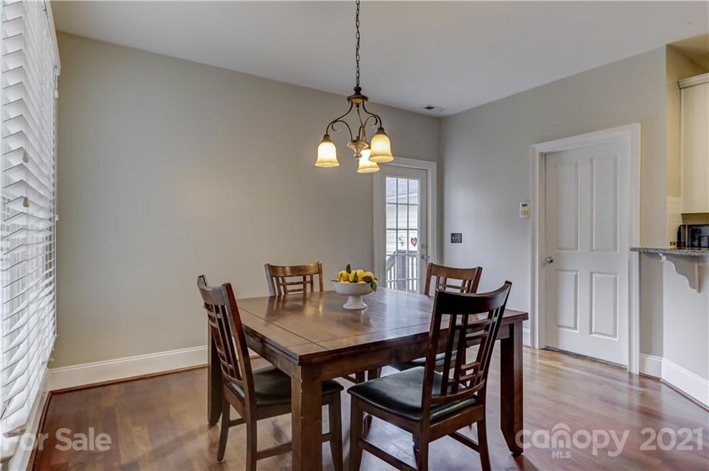 1178 Market Street Fort Mill, SC 29708 - Photo 21 of 47 a dining room with wooden floor a chandelier a wooden table and chairs