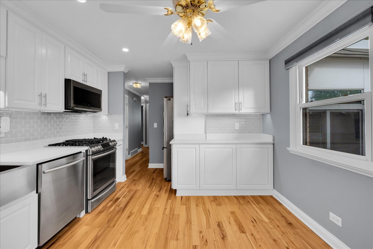 1427 Busse Road Mount Prospect, IL 60056 - Photo 12 of 38 a kitchen with a sink a microwave and cabinets