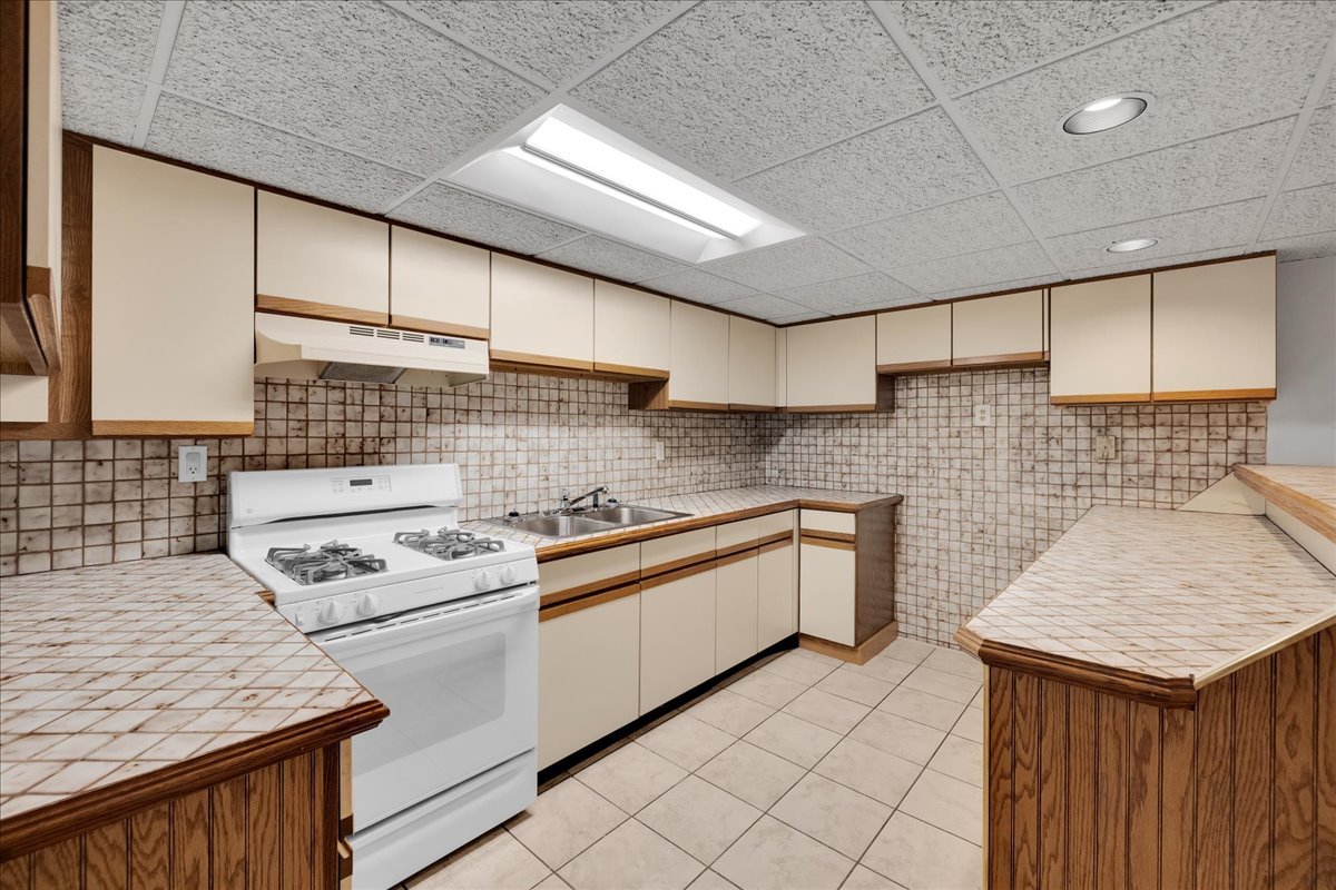 1427 Busse Road Mount Prospect, IL 60056 - Photo 16 of 38 a kitchen with stainless steel appliances granite countertop a sink stove and cabinets