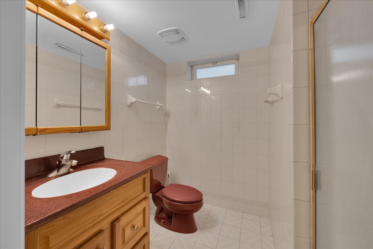1427 Busse Road Mount Prospect, IL 60056 - Photo 18 of 38 a bathroom with a granite countertop sink toilet and mirror