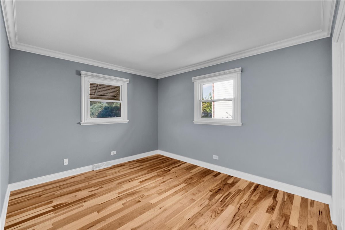 1427 Busse Road Mount Prospect, IL 60056 - Photo 21 of 38 a view of an empty room with wooden floor and a window