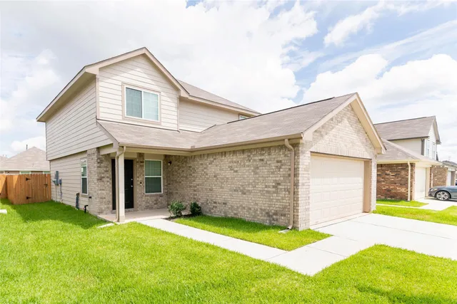 a view of a house with a big yard and large tree