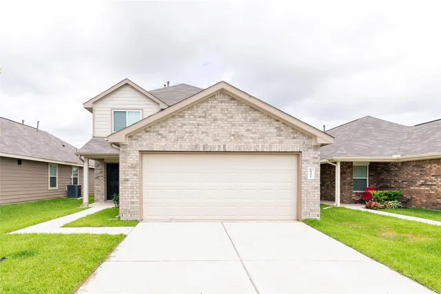 a view of a house with a yard plants and a big yard