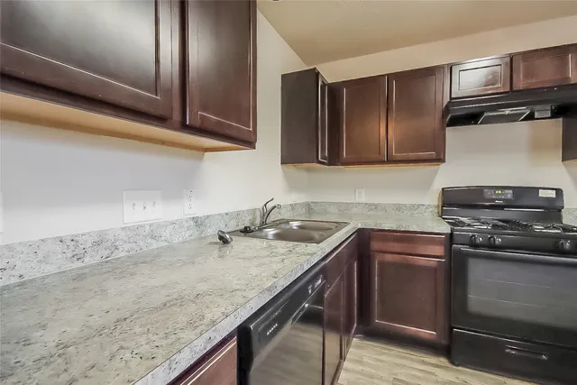 a kitchen with granite countertop stainless steel appliances and wooden cabinets