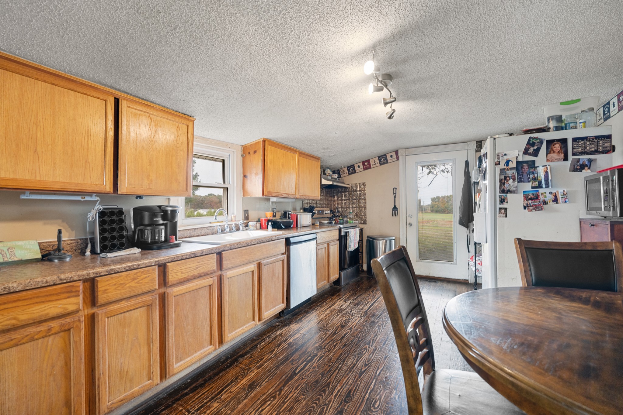 709 Isbell Turn Road Winchester, TN 37398 - Photo 5 of 22 a large kitchen with stainless steel appliances granite countertop a stove a sink dishwasher a dining table and chairs with wooden floor