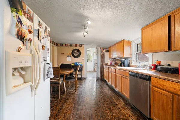 a kitchen with stainless steel appliances kitchen island granite countertop a stove a sink and a refrigerator