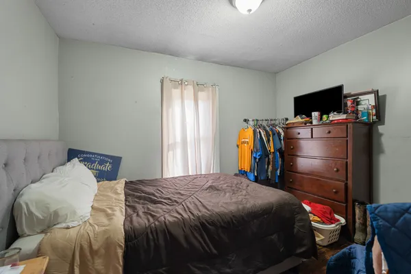 a bedroom with a bed and a flat screen tv