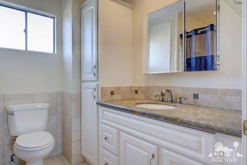 34404 Laura Way Rancho Mirage, CA 92270 - Photo 21 of 31 a bathroom with a granite countertop toilet sink and mirror