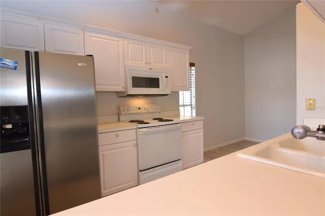 a kitchen with stainless steel appliances a refrigerator sink and microwave