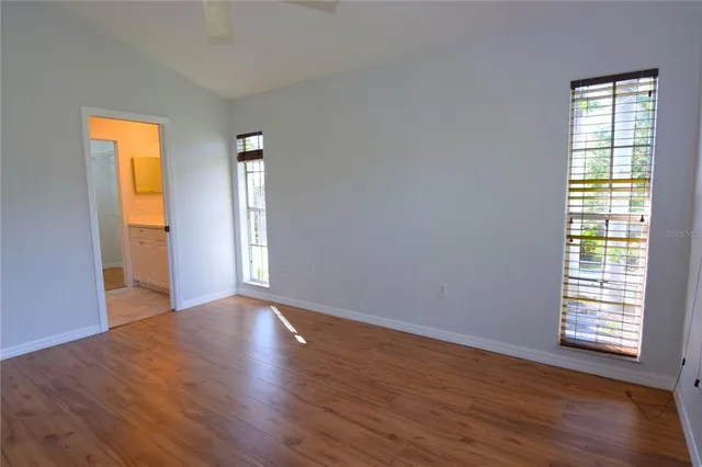 an empty room with wooden floor and a window