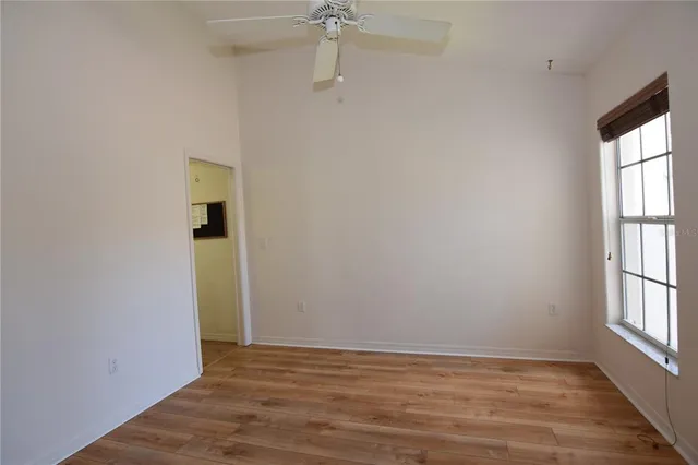 a view of an empty room with a window and wooden floor