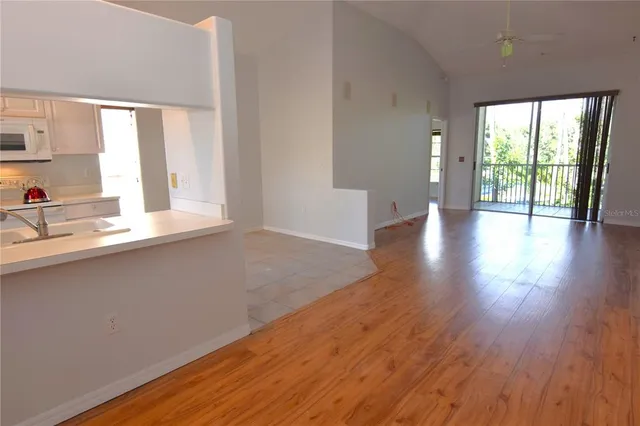 a view of a kitchen with wooden floor and a sink
