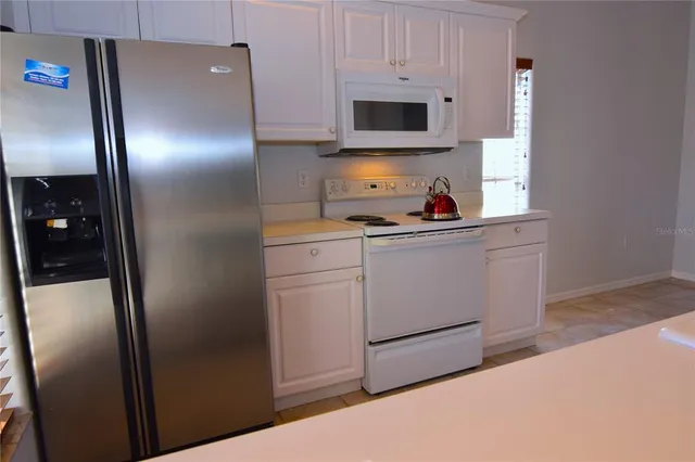 a kitchen with stainless steel appliances a refrigerator sink and microwave