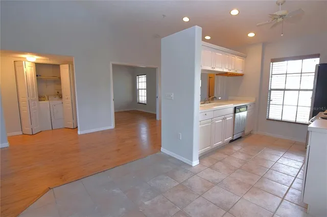 a view of a kitchen with kitchen island granite countertop wooden cabinets and stainless steel appliances