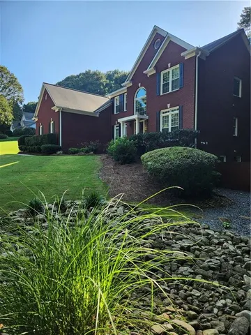 a living room with couches and a dining table with wooden floor