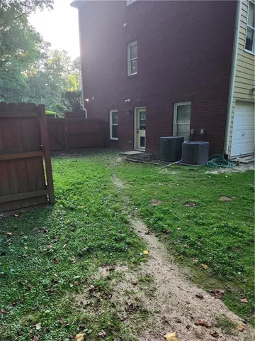a spacious bedroom with a bed a dresser and a chandelier
