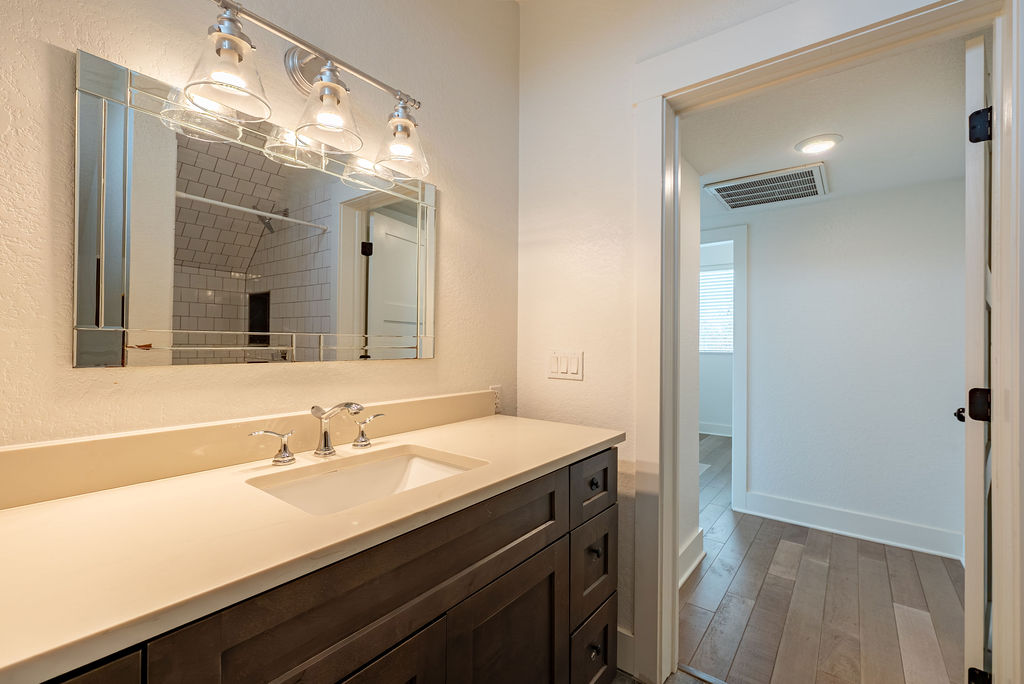 2016 Peoples Street Austin, TX 78702 - Photo 23 of 28 Full bathroom with vanity, tiled shower, and light wood-style floors