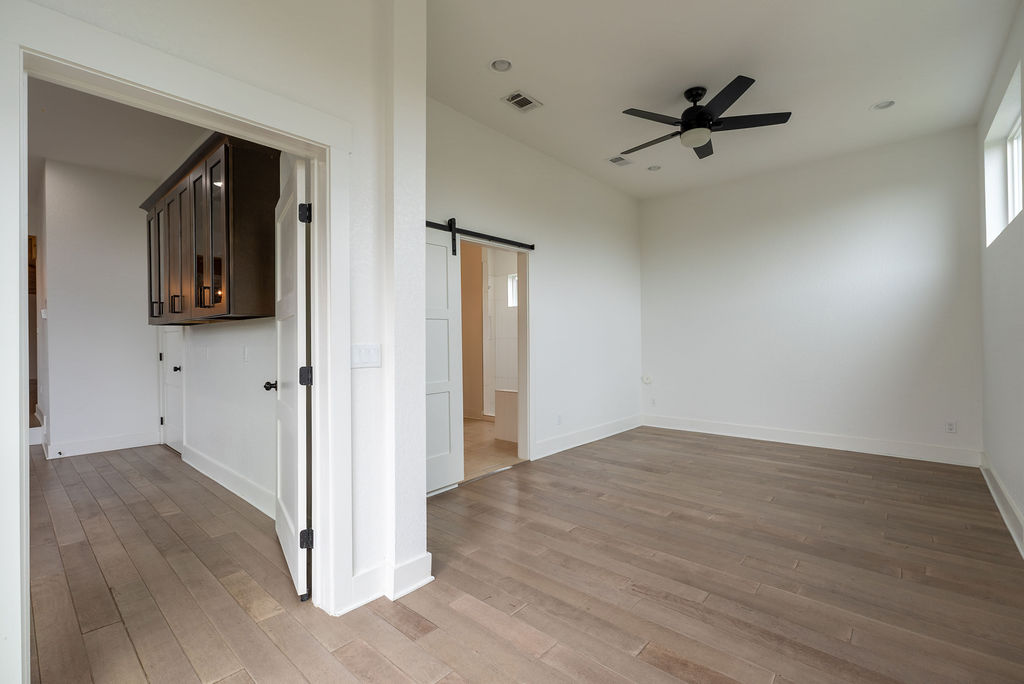 2016 Peoples Street Austin, TX 78702 - Photo 8 of 28 Spare room featuring a barn door, light wood-style floors, ceiling fan, and recessed lighting