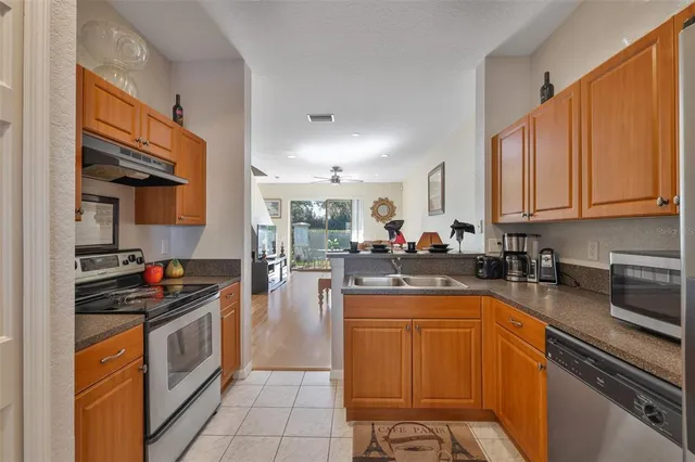 a kitchen with stainless steel appliances granite countertop a stove a sink dishwasher and cabinets with wooden floor
