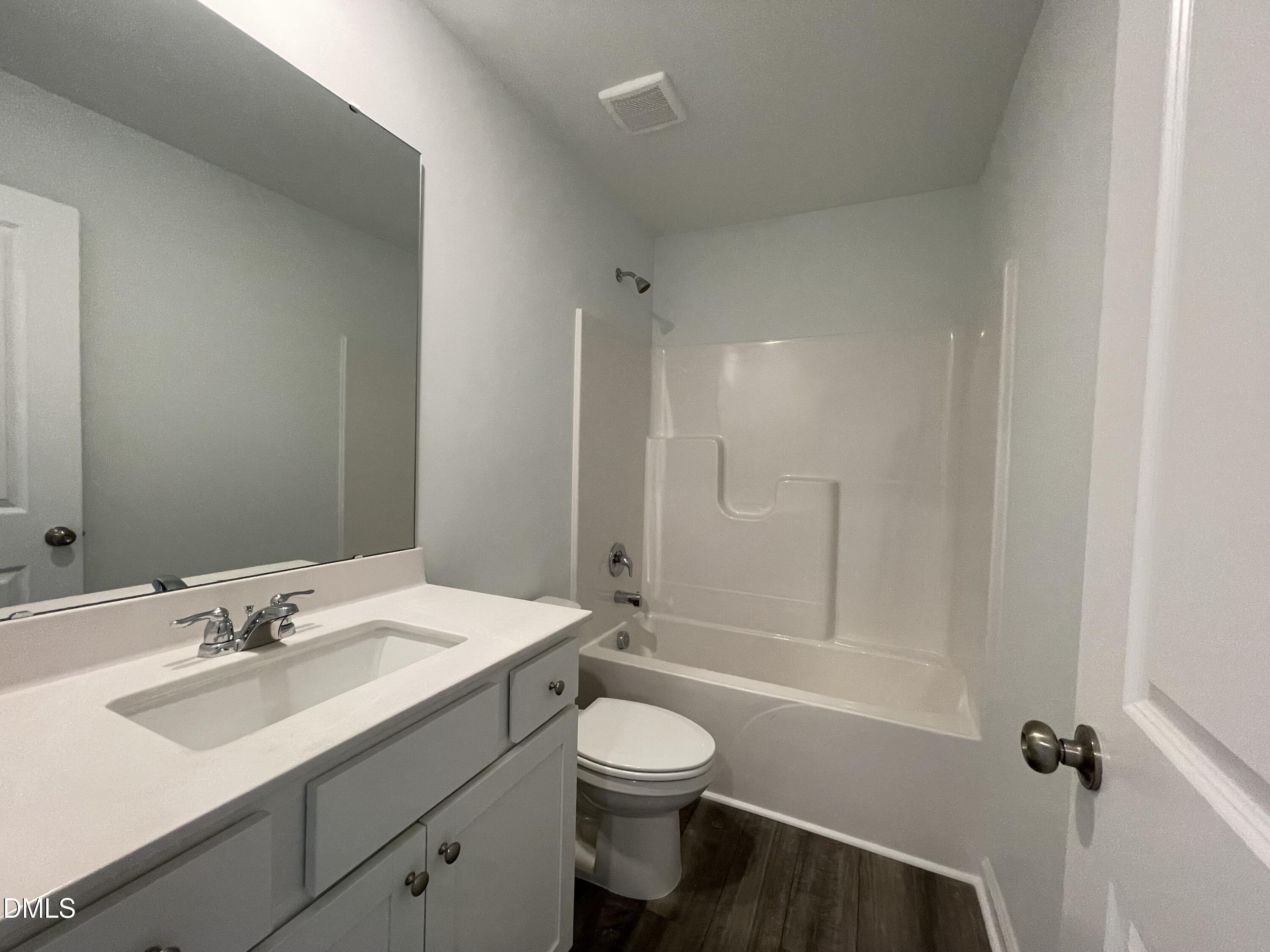 236 Lily Patch Lane Smithfield, NC 27577 - Photo 17 of 46 a bathroom with a toilet a sink a mirror and vanity