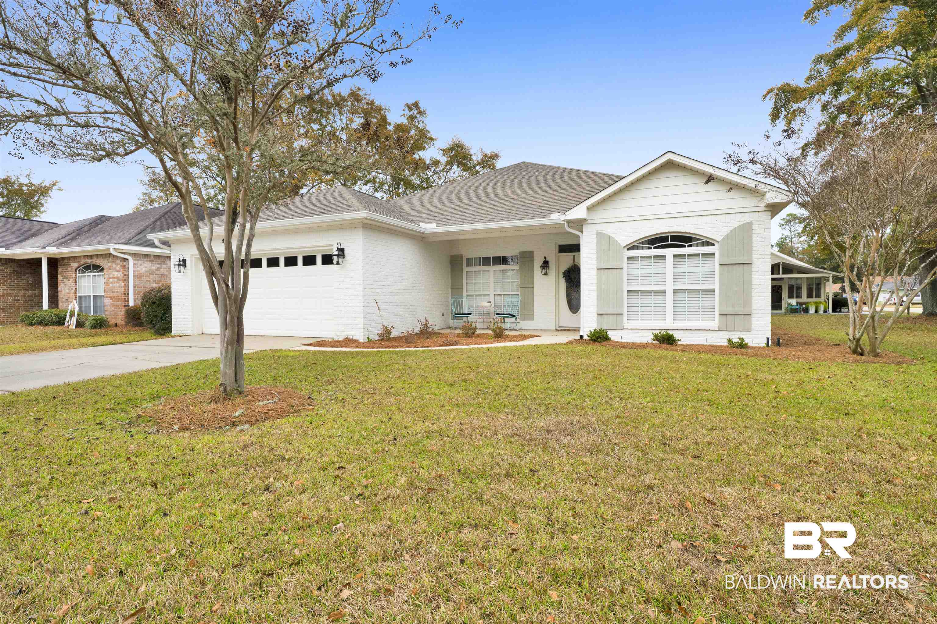 Single story home featuring concrete driveway, a front yard, a porch, and brick siding