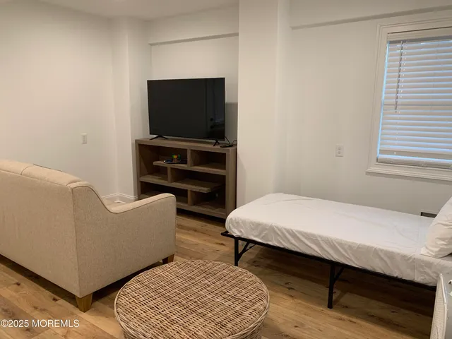 a bedroom with furniture and a flat screen tv