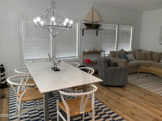 a living room with furniture a chandelier and a dining table