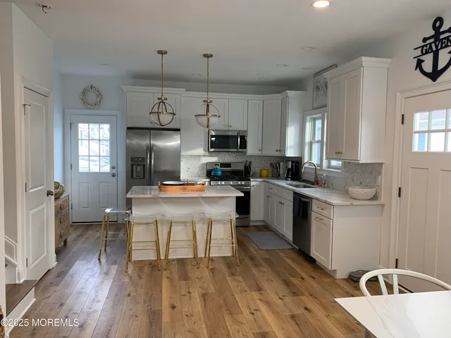 a kitchen with cabinets a sink a window and stainless steel appliances