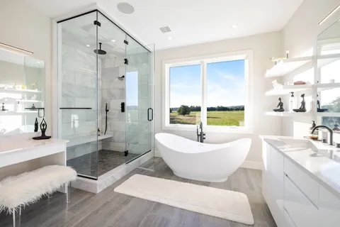 a spacious bathroom with a bathtub shower sink mirror and toilet