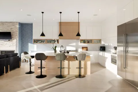 a kitchen with stainless steel appliances kitchen island granite countertop a stove and white cabinets