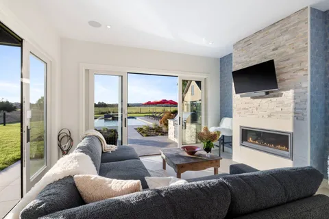 a living room with furniture a flat screen tv and a floor to ceiling window
