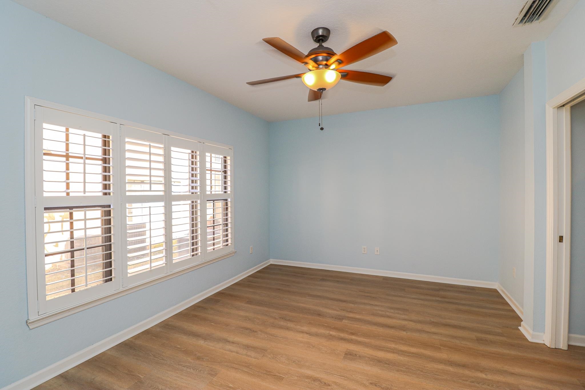 305 Via Castilla, Unit 103 St. Augustine, FL 32095 - Photo 12 of 34 an empty room with wooden floor and windows
