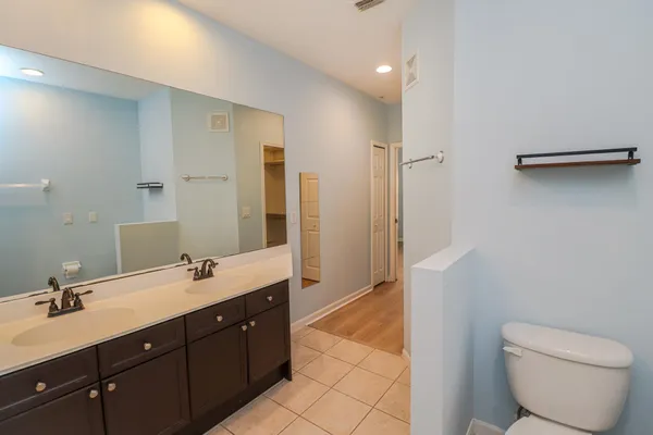 a spacious bathroom with a double vanity sink toilet mirror and bathtub