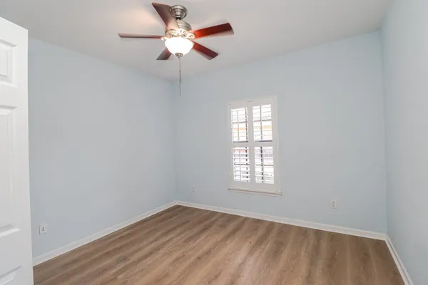 an empty room with a window and a fan